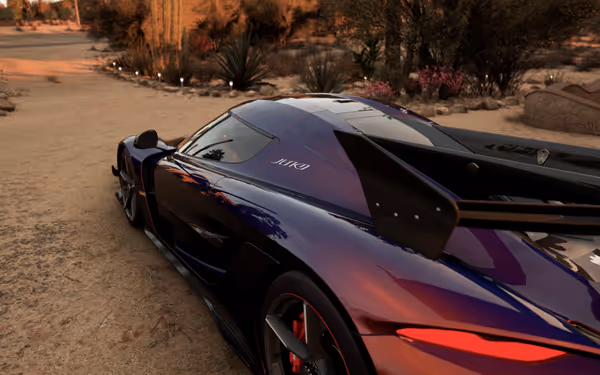 Purple sports car with large rear wing parked on a desert road.