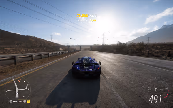 Blue sports car driving on highway under power lines, clear sky."