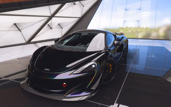A sleek black sports car with reflective details is parked inside a modern showroom.