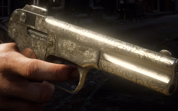 An engraved silver pistol with a scrollwork design.