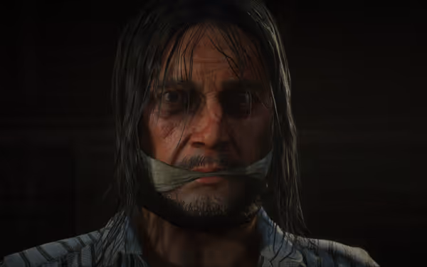 A person with long hair, tied mouth, wearing a striped shirt in a dark room