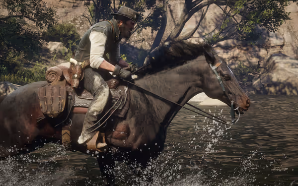 A man riding a saddled horse crossing shallow water, surrounded by trees.