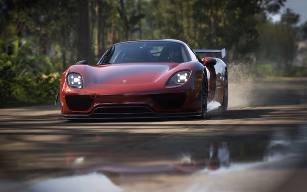 A red sports car driving on a wet road, water kicked high into the air from the tires, the reflection seen in a puddle in front of the car