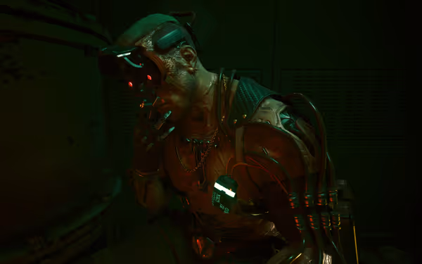 A cybernetic man with glowing red eyes smokes, wires and tubes connected to him
