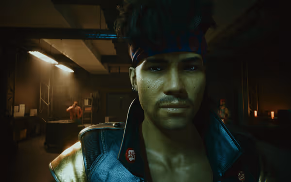 A man with a headband and mustache stares intensely in a dimly lit warehouse