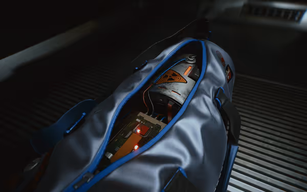 A gray duffel bag holds a high-tech explosive device with glowing red lights