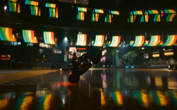 A motorcyclist performs a wheelie on a wet street surrounded by neon lights.