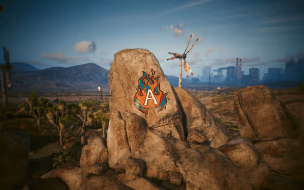 A large rock features a painted flaming "A" symbol in a desert landscape.
