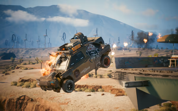 A burning armored vehicle soars off a broken bridge amid explosions in a desert.
