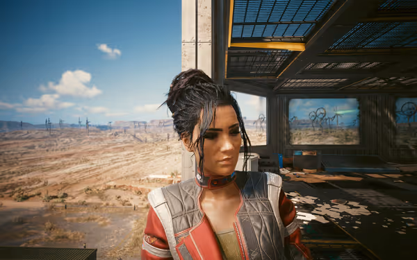 A woman with dark braided hair and a red jacket stands in a desert outpost.