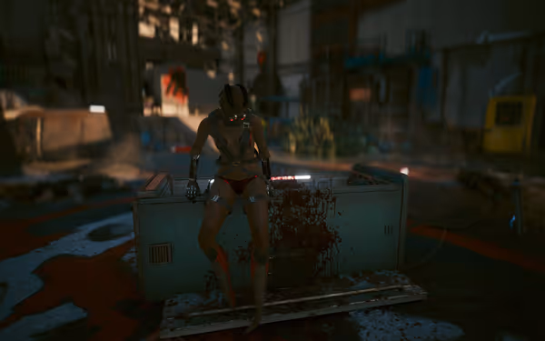 A cybernetic woman with glowing eyes sits on a bloodstained machine in a warehouse.