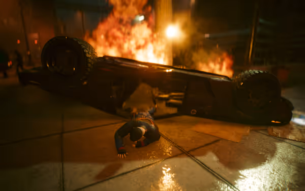 A man crawls from an overturned car as flames engulf the background