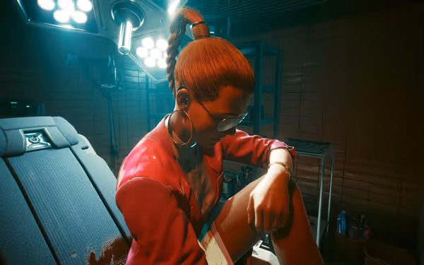A woman with glasses and braided hair sits in a dimly lit medical room
