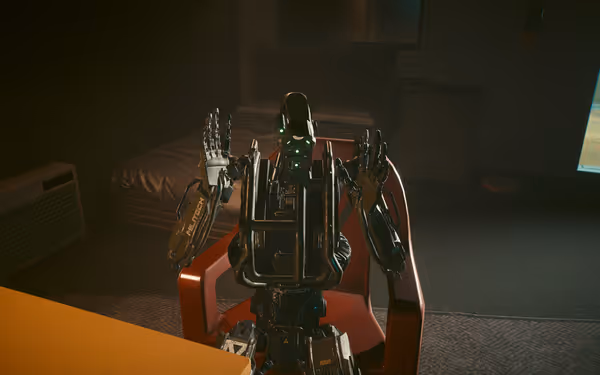 A humanoid robot with green glowing eyes raises its hands while sitting indoors.