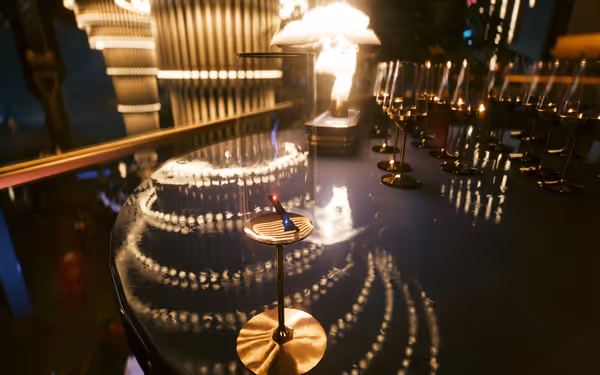 A sleek black data shard glows red and blue inside a champagne flute on a reflective bar.