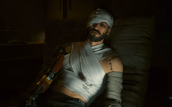 Man with bandaged eye and torso rests in chair, revealing cybernetic arm and scars.