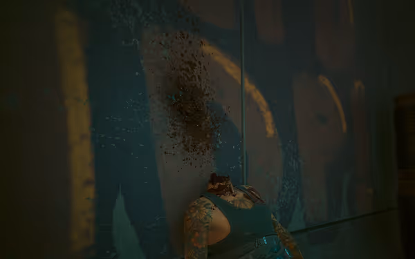 Headless tattooed body slumped against blood-splattered wall under dim industrial lighting.