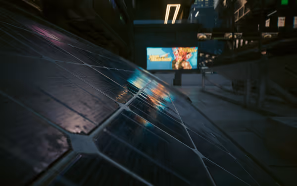 Close-up of reflective solar panels with a colorful advertisement billboard in the background.