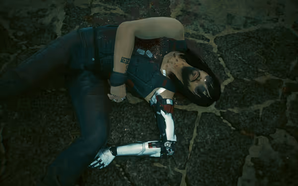 Man with cybernetic arm lies motionless on cracked pavement, blood splattered on chest.