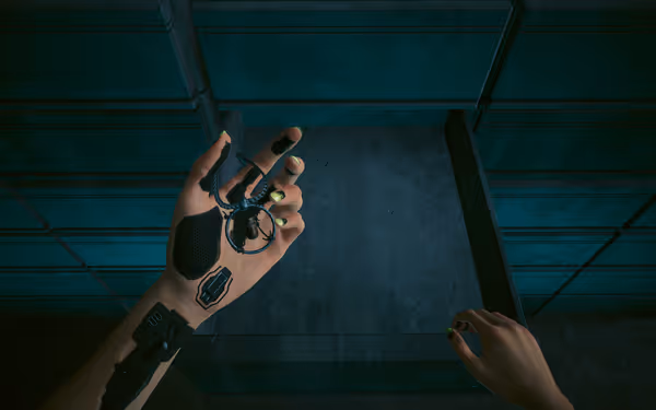 A cybernetic hand holds a necklace with a bullet charm in a dimly lit room.
