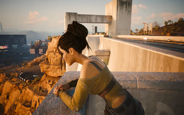 A woman with dreadlocks leans on a concrete ledge overlooking a desert landscape.