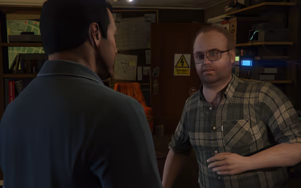 Two men talk in a cluttered room, one facing forward looking slightly confused.