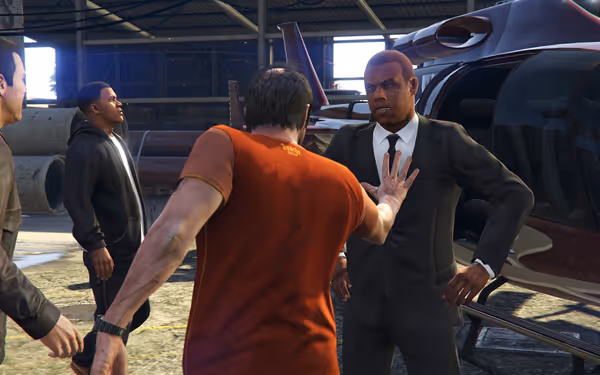 A man in an orange prison jumpsuit faces a well-dressed man in a warehouse.