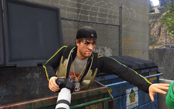 A person with a camera leans out of a dumpster, reaching toward someone in green.