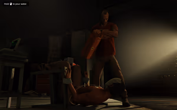 A man in a red shirt is holding a jerrycan above a tied-up person.