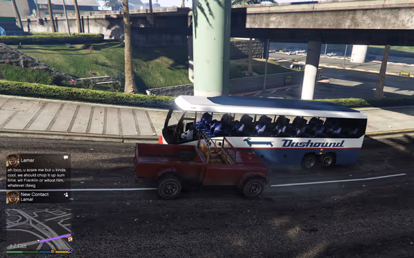 A red pickup truck and a blue Dashound bus stop on a sunlit city street.