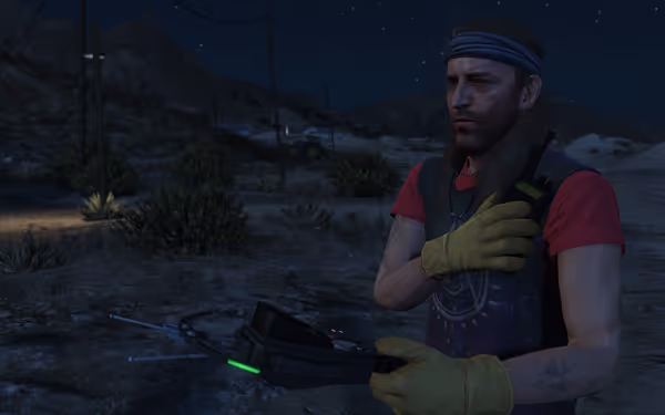 Bearded man in red shirt and yellow gloves working outdoors at night with green light.