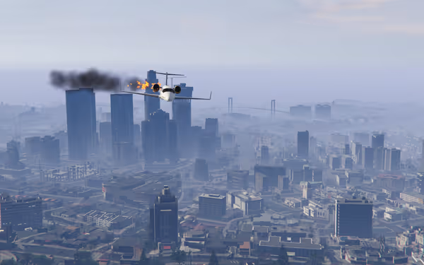 A jet plane flies over a city skyline, trailing fire and thick black smoke.