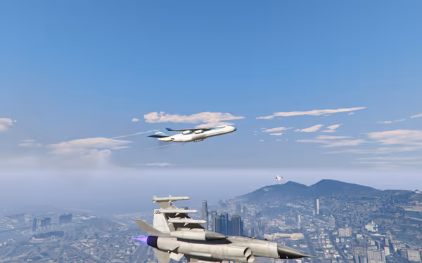 A passenger jet flies in the sky while a military jet is closer above a city.