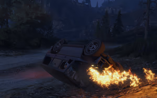 An overturned SUV is on fire at night, flames coming from underneath on a dirt road.