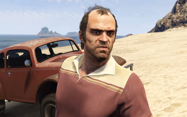 A man in a red shirt stands on a sandy beach beside a rusty car.