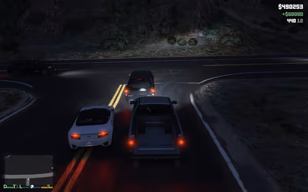 A large truck carries two cars on a nighttime highway curve with game interface showing money.