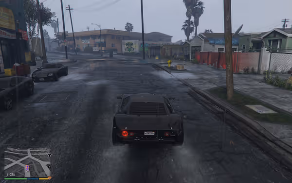 A black sports car drives through a rainy, urban street lined with houses and parked cars.