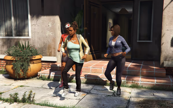 Three women in athletic wear jogging together on a sunlit sidewalk outside a building.