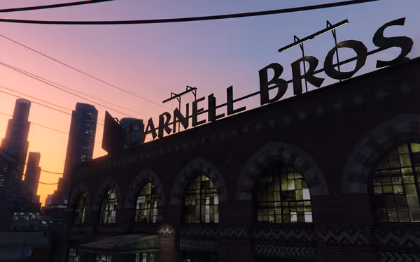 A brick building with arched windows displays a large rooftop sign reading "DARNELL BROS".
