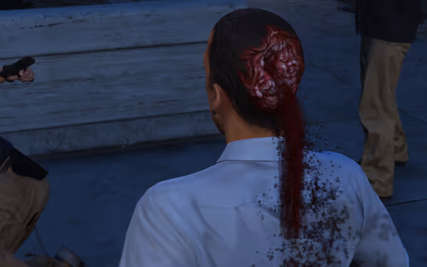 A man’s head is injured with blood and brain exposed, others stand nearby holding guns.