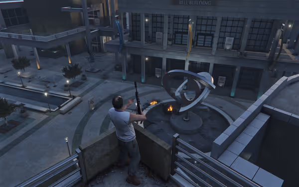 A man holding a rifle stands on a balcony overlooking a courtyard sculpture.