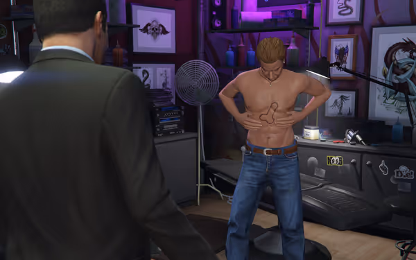 A shirtless man shows off a fresh tattoo while another man stands nearby watching.