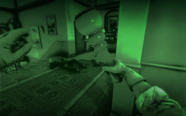 A first-person view through a green night vision filter, holding a flashlight, with a person lying motionless on the floor in a house hallway.