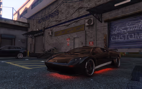 A sleek black sports car with red underglow is parked outside an auto repair shop.