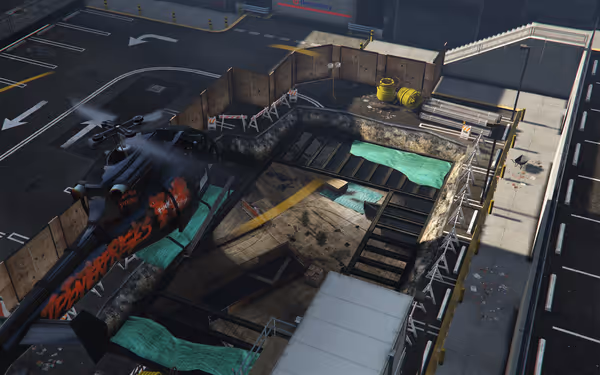 A black helicopter with red graffiti hovers above a fenced construction site with exposed pipes.