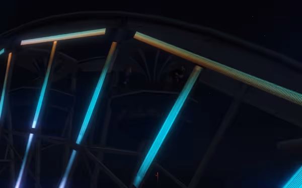 Two men are seated on a ferris wheel at night, one aiming a gun.