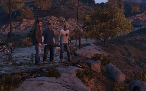 Three men stand on a dirt path in a rural area with rocky terrain.
