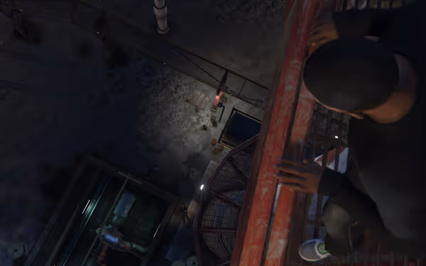 A person is looking down from a red industrial railing at the ground below.