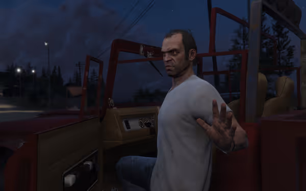 A man with a stern expression sits in a red vehicle, holding up his hand.