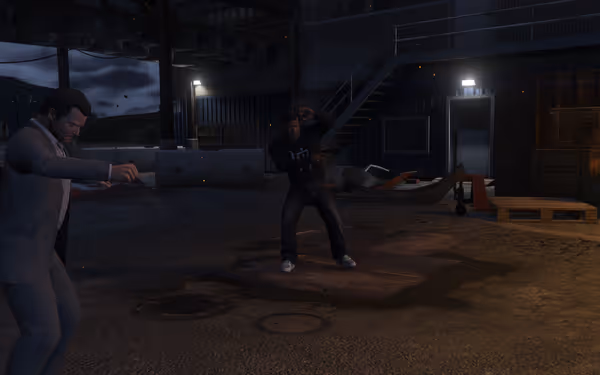 Two men are standing in an industrial area, one in a suit, the other in casual clothes.